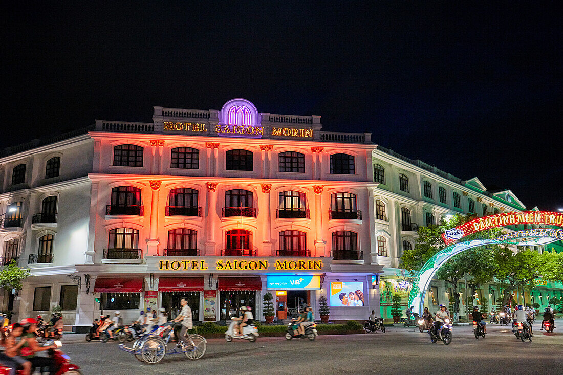  Außenansicht des Saigon Morin Hotels, einem Luxushotel aus der Kolonialzeit, das nachts farbenfroh beleuchtet ist. Hue, Vietnam. 