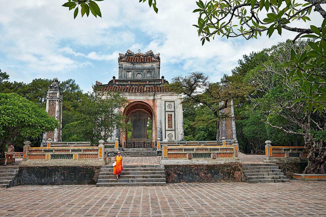 A woman walks at the Stone Stele Pavilion at the Tomb of Tu Duc. Hue, Vietnam.