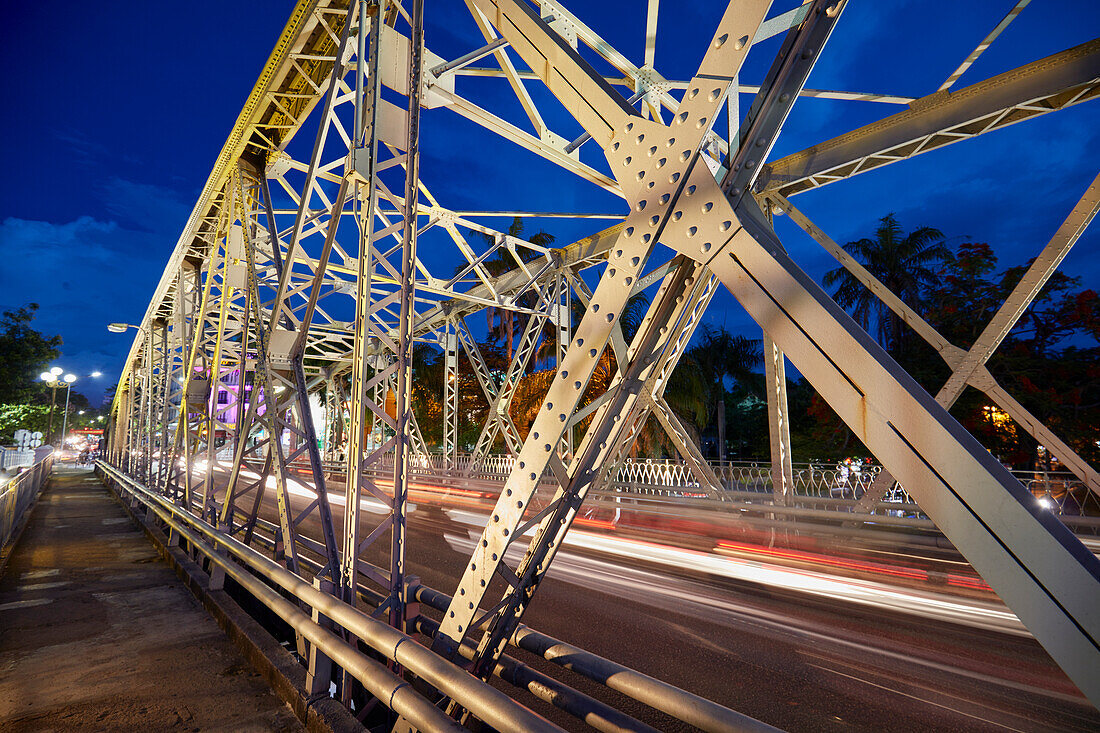 Truong Tien Bridge (designed by Gustave Eiffel) across Perfume River illuminated at dusk. Hue, Vietnam.