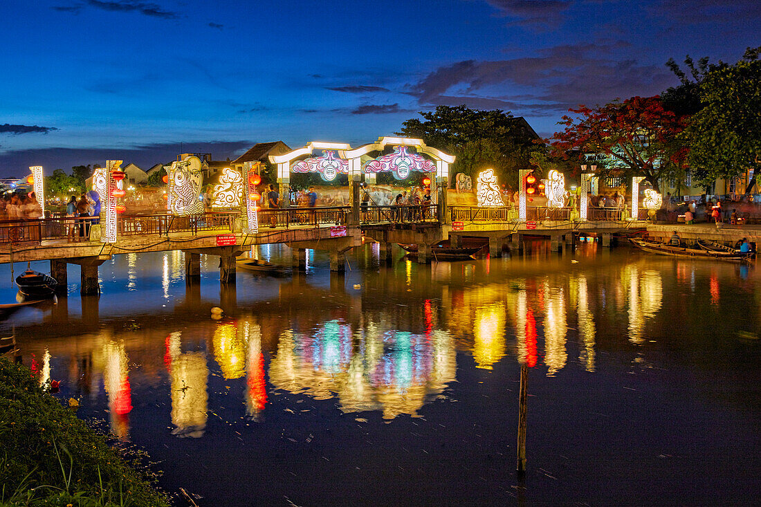  Blick auf die Cau An Hoi-Brücke, die in der Abenddämmerung beleuchtet und im Thu Bon-Fluss reflektiert wird. Antike Stadt Hoi An, Provinz Quang Nam, Vietnam. 