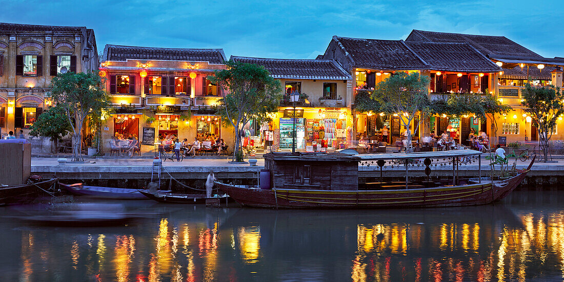  Alte Häuser entlang des Flusses Thu Bon in der Altstadt von Hoi An, beleuchtet in der Abenddämmerung. Hoi An, Provinz Quang Nam, Vietnam. 