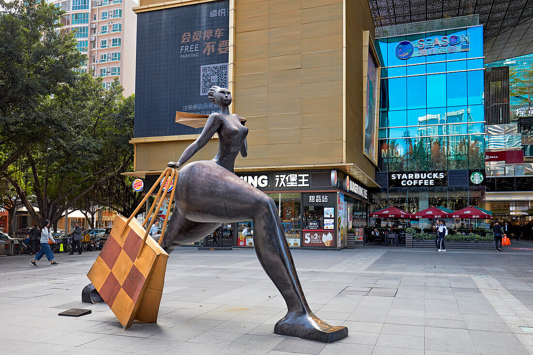  Statue einer Frau mit Einkaufstasche vor dem InTown Einkaufszentrum im zentralen Geschäftsviertel Futian (CBD). Shenzhen, Provinz Guangdong, China. 