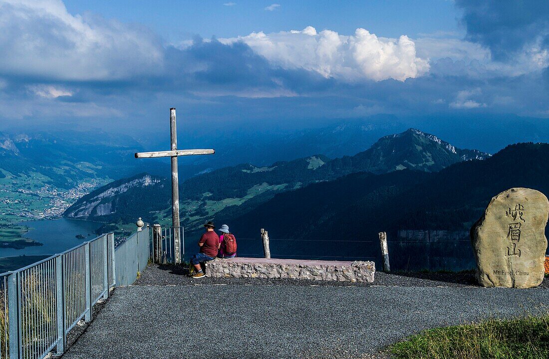  Evening mood on the Rigi, couple under a summit cross, boulder from the partner mountain Emei Shan (China), view of Lauerz and Lake Lauerz, Canton Lucerne, Switzerland 