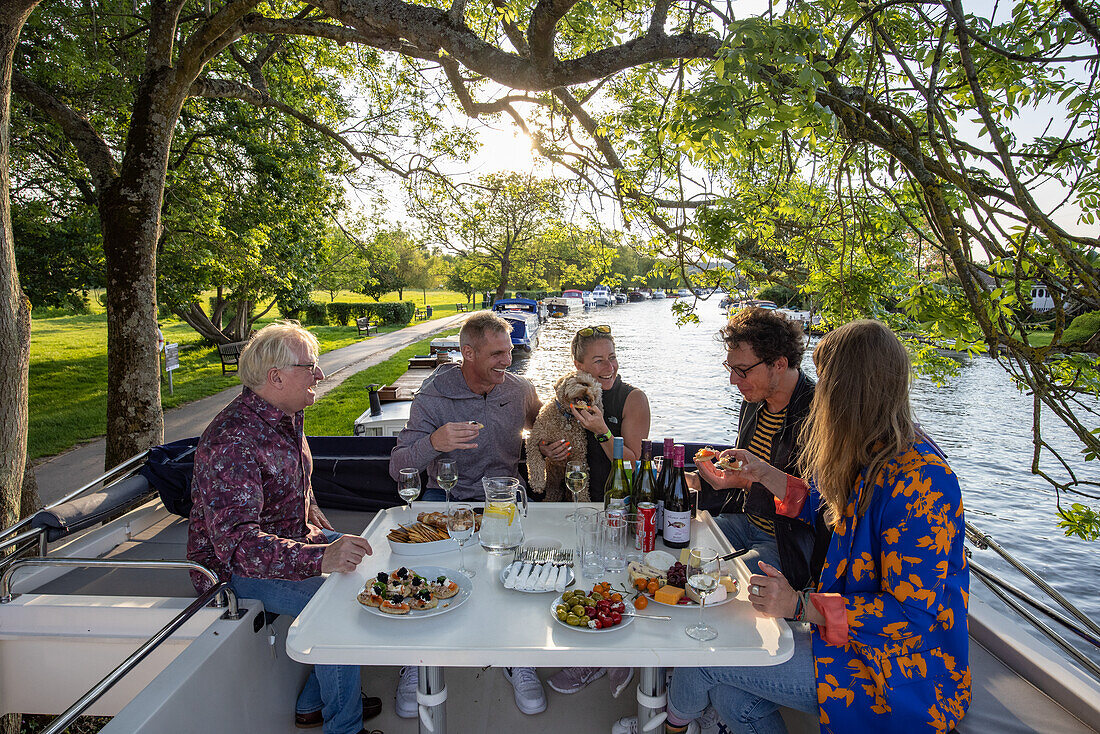  Friends enjoy wine and canapés on deck of a Le Boat Horizon 4 houseboat moored on the River Thames in Henley-on-Thames, Oxfordshire, England, United Kingdom, Europe 