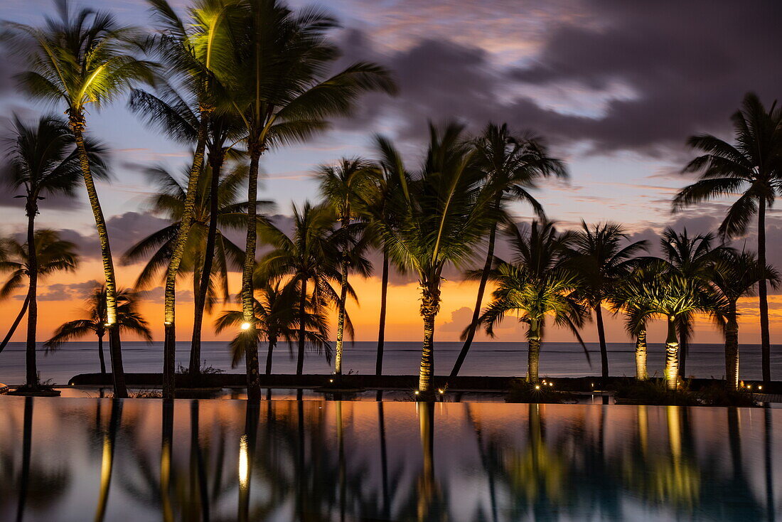 Spiegelung von Kokospalmen im Swimmingpool des Trou aux Biches Beachcomber Golf Resort & Spa bei Sonnenuntergang, Trou aux Biches, Pamplemousses, Mauritius, Indischer Ozean