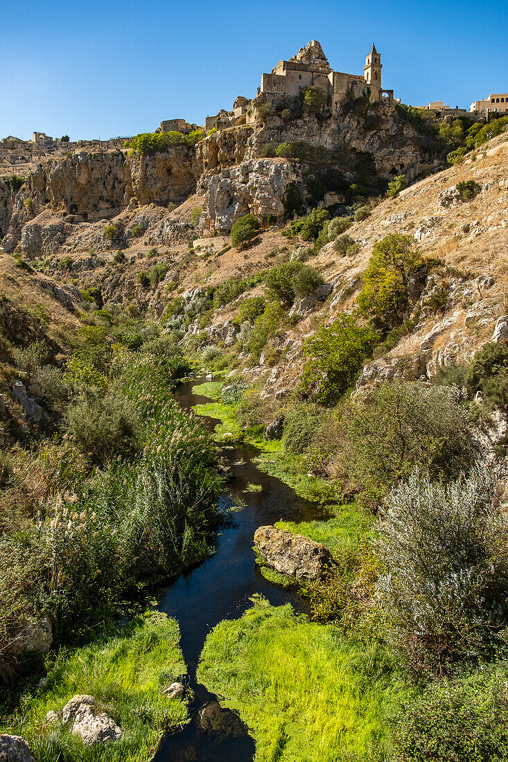  Kirche St. Peter und Paul (San Pietro Caveoso) und der Fluss Gravina im Park Murgia Materana (Parco della Murgia Materana), Matera, Basilikata, Italien. 