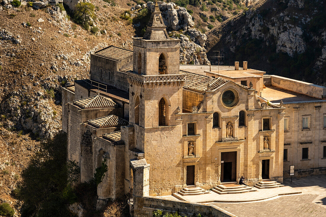 Saint Peter and Saint Paul Church (San Pietro Caveoso) with the Murgia Materana park (Parco della Murgia Materana) in the background, Matera, Basilicata, Italy.