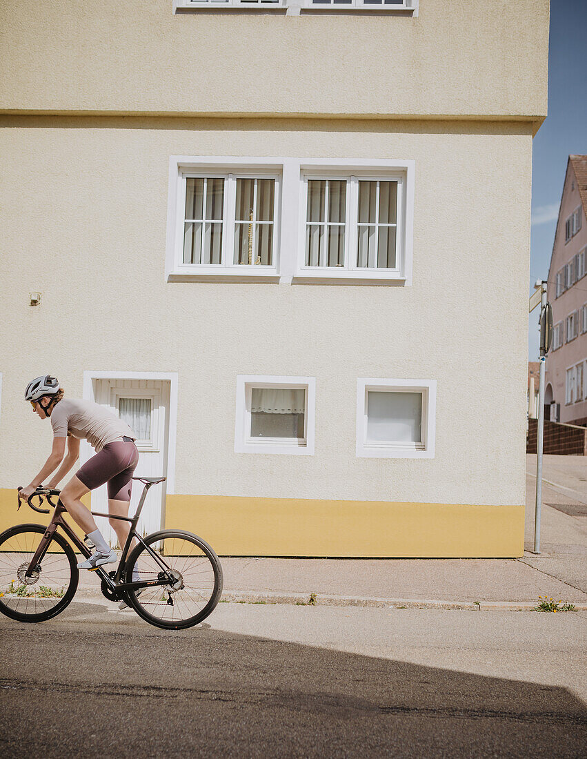 Roadbiken, Frau beim Rennrad fahren auf der Straße