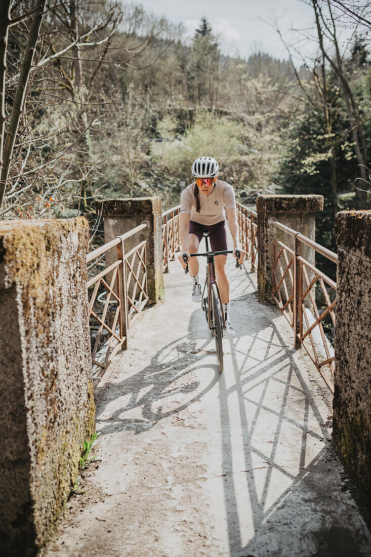 Roadbiken, Frau beim Rennrad fahren auf der Straße