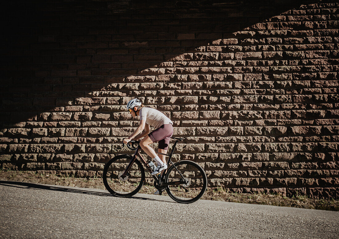 Roadbiken, Frau beim Rennrad fahren auf der Straße