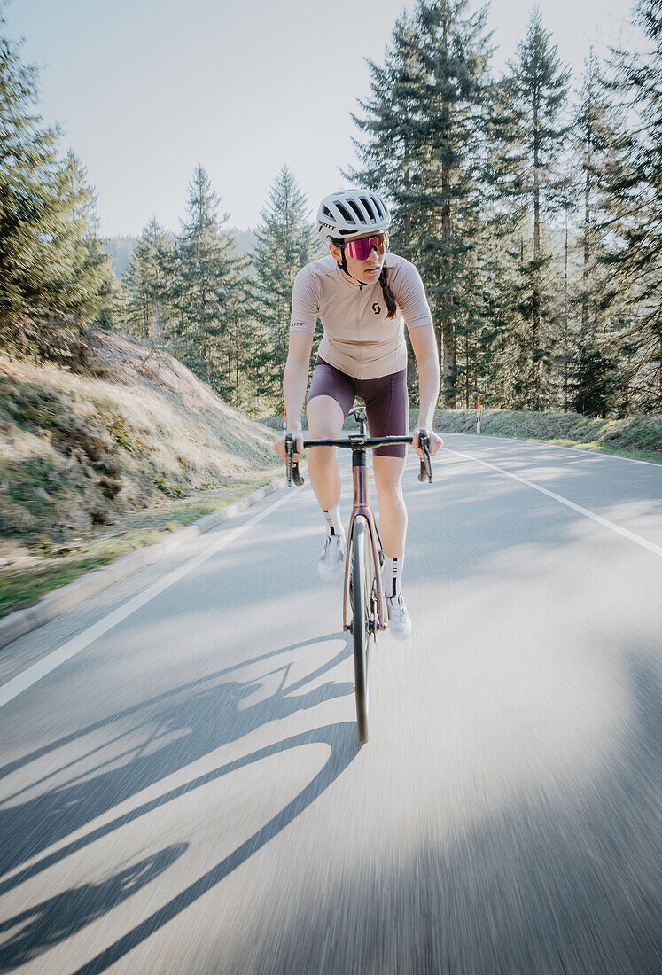 Roadbiken, Frau beim Rennrad fahren auf der Straße