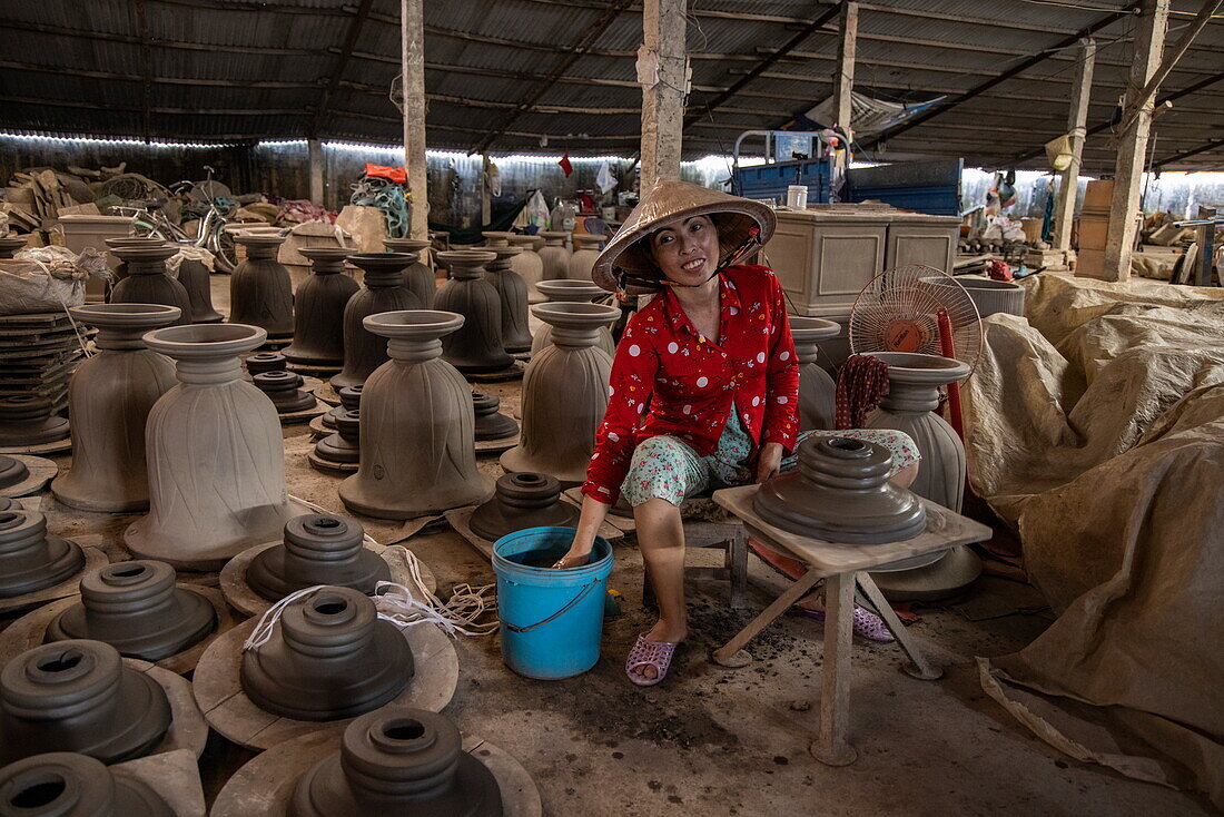  Woman wearing traditional Vietnamese conical hat making pottery in a factory, Long Son, Phu Tan, An Giang, Vietnam, Asia 