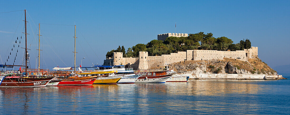 Boats moored at pier near the Castle on Pigeon Island. Kusadasi, Aydin Province, Turkey.