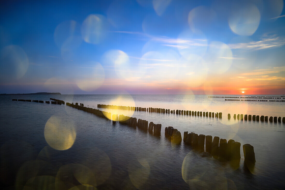  X-buhne abstract, cross-buhne on the Baltic Sea beach Dranske at sunset with light reflections, golden hour, Baltic Sea, Baltic Sea island, Rügen, Germany\n 