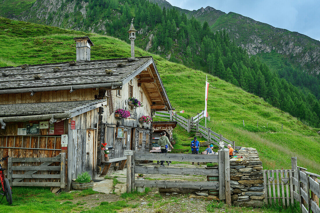 Mehrere Personen sitzen zur Rast an Alm, Alprechtalm, Ahrntal, Venedigergruppe, Südtirol, Italien