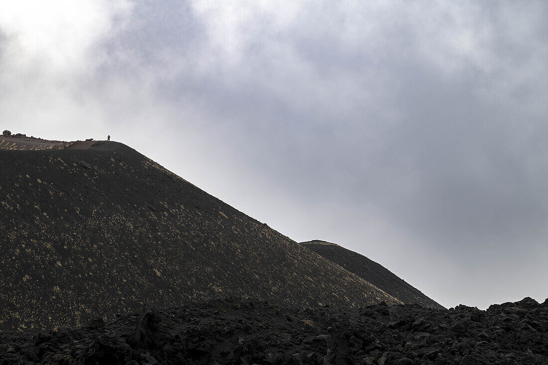 Blick auf Nebenkrater des Ätna, Mann steht auf Kraterrand, Krater Silvestri, Piccolo cratere sud dell'Etna, UNESCO Weltnaturerbe Vulkan, Ätna, Etna, Italien, Sizilien