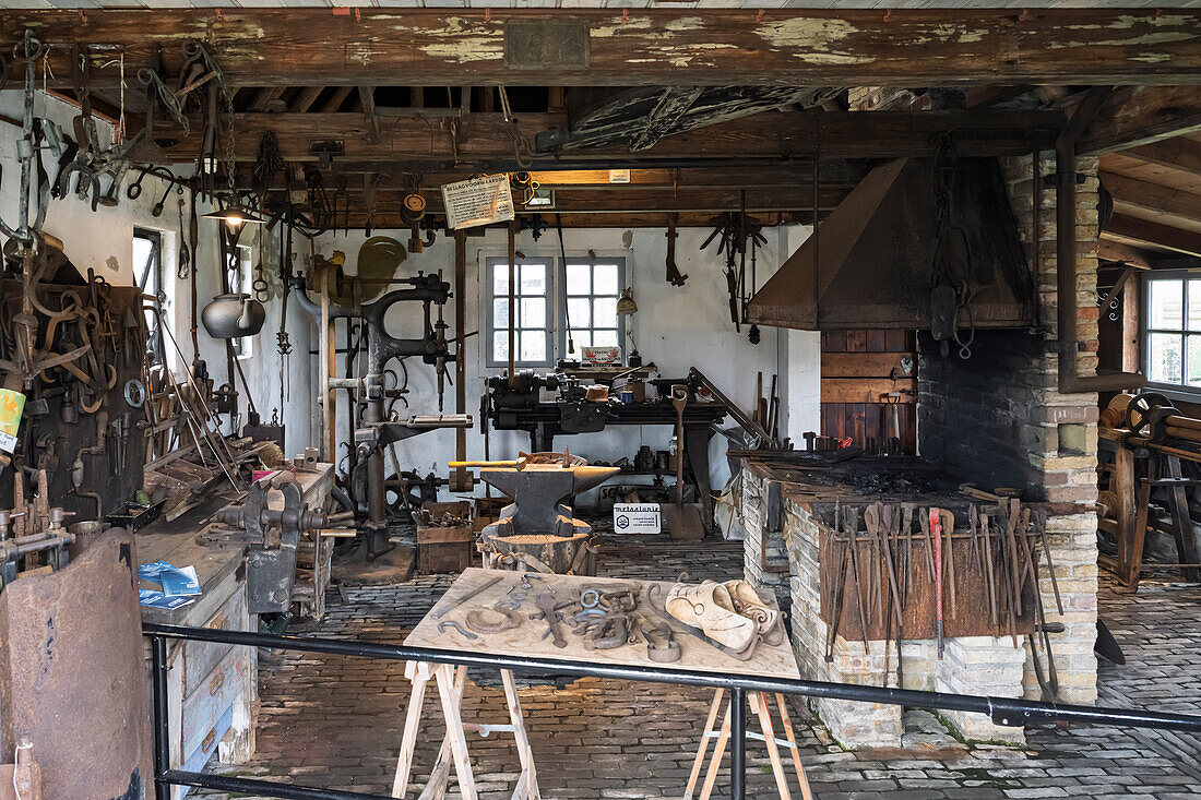 A vintage blacksmith workshop with tools, an anvil, and a forge.