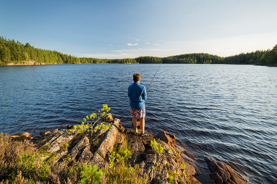  a boy with a fishing rod in Glaskogen Nature Reserve, Värmland County, Sweden 