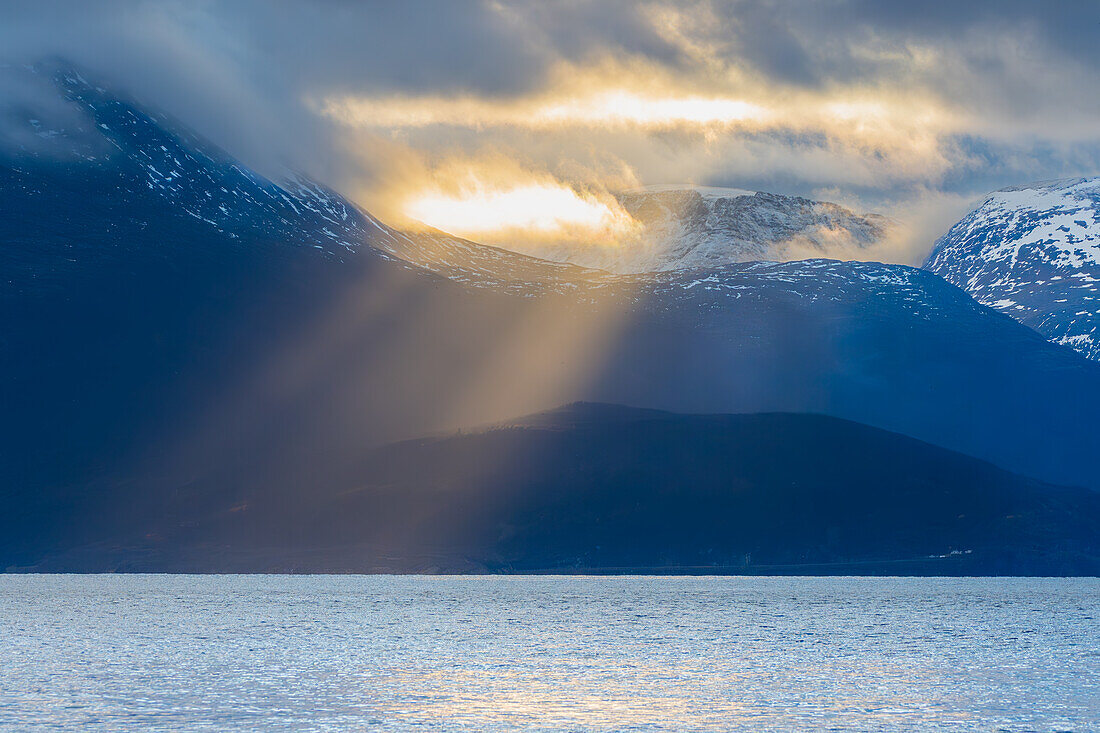 Norwegen, Skjervøy, Sonnenstrahlen in Küstenlandschaft am Abend