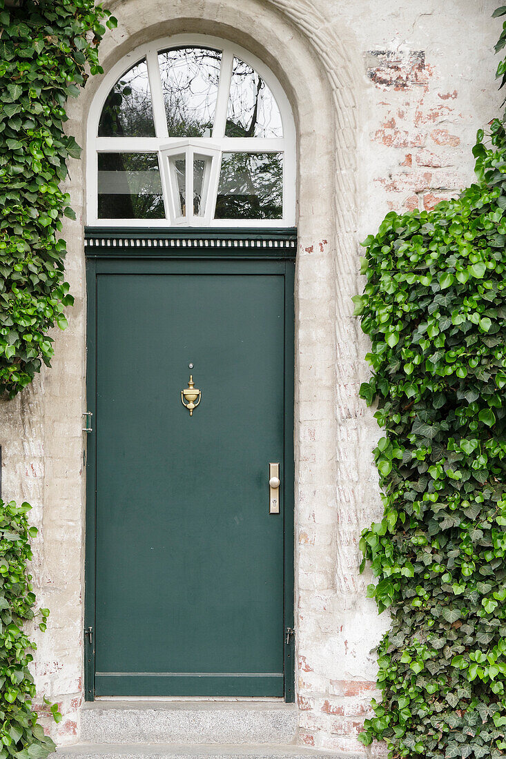  Dark green front door on ivy-covered facade 