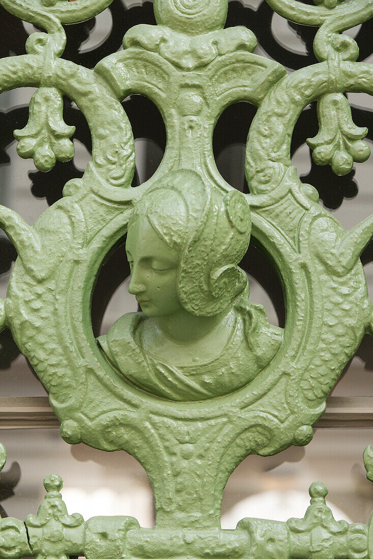  Headshot of a woman in an antique wrought iron entrance door 