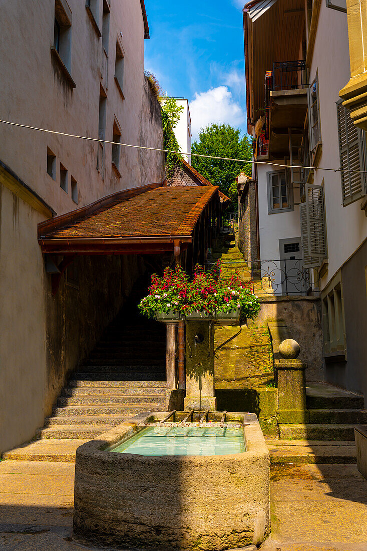 Covered Staircase with Water Fountain in Old Town in a Sunny Summer Day in City of Fribourg, Canton Fribourg, Switzerland.