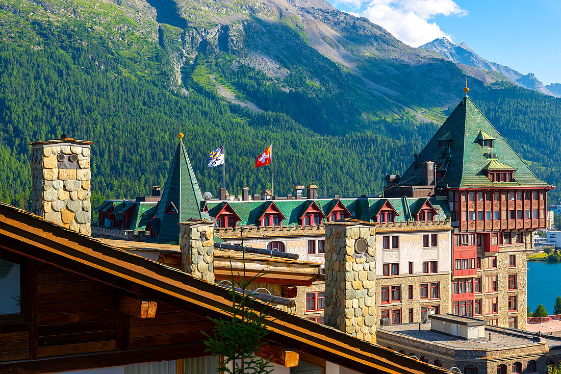 Luxushotel mit blauem Himmel und Bergen an einem sonnigen Sommertag in St. Moritz, Graubünden, Schweiz.