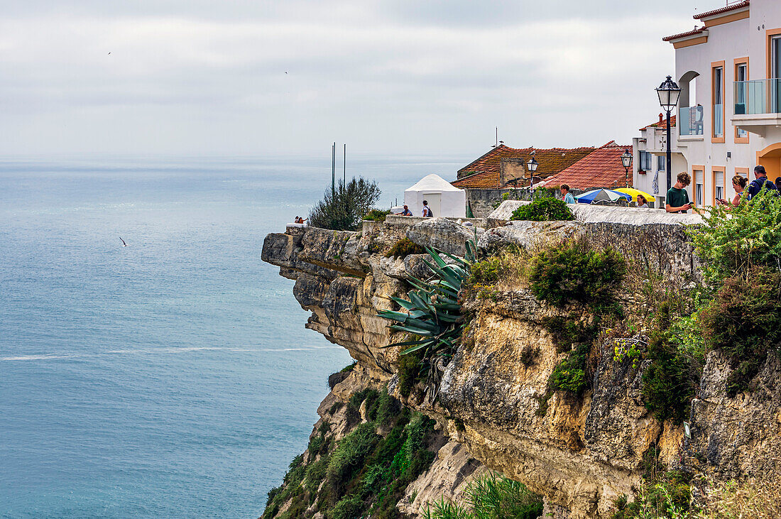  Colorful houses above a cliff on the coast of Nazare, Portugal, along the Atlantic Ocean, Nazare, Portugal 