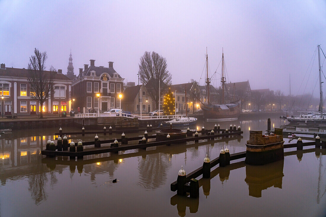 Typische Gracht in der nebeligen Abenddämmerung, Harlingen, Friesland, Niederlande