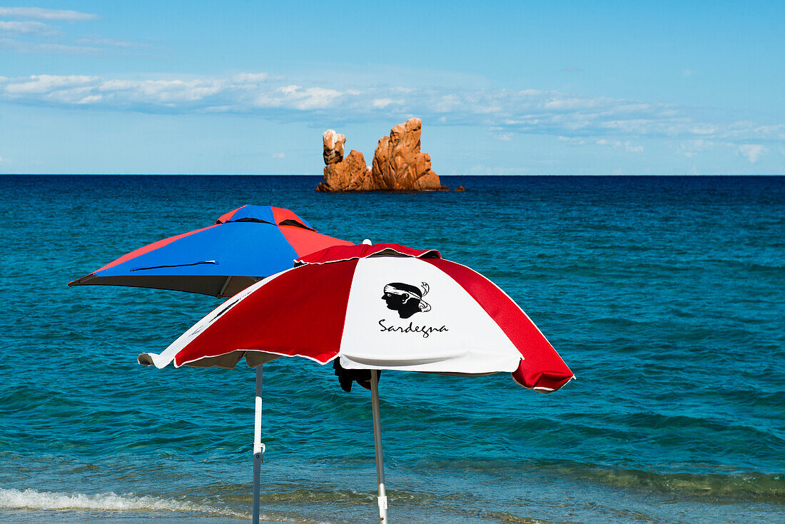  Beach umbrellas and red rocks, Spiaggia di Cea, Tortoli, Sardinia, Italy 