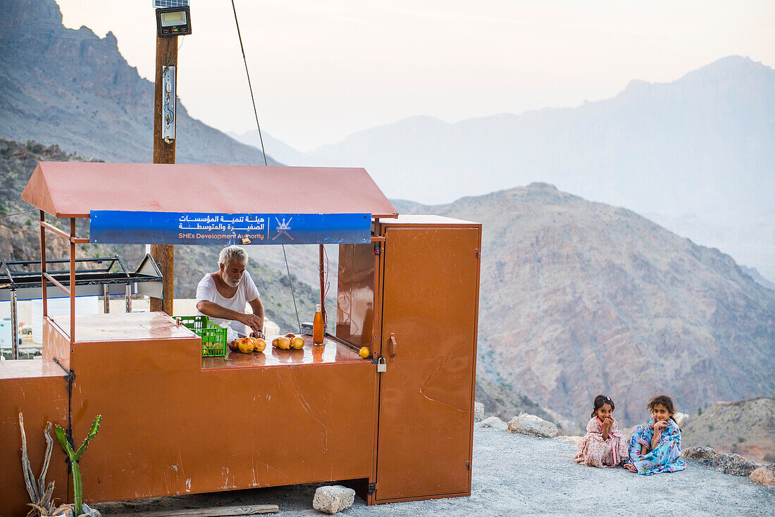 Mann verkauft Granatapfel beim Dorf Wakan, westliches Hadschar-Gebirge, Gouvernement Süd-Batina, Sultanat Oman, Arabische Halbinsel, Naher Osten