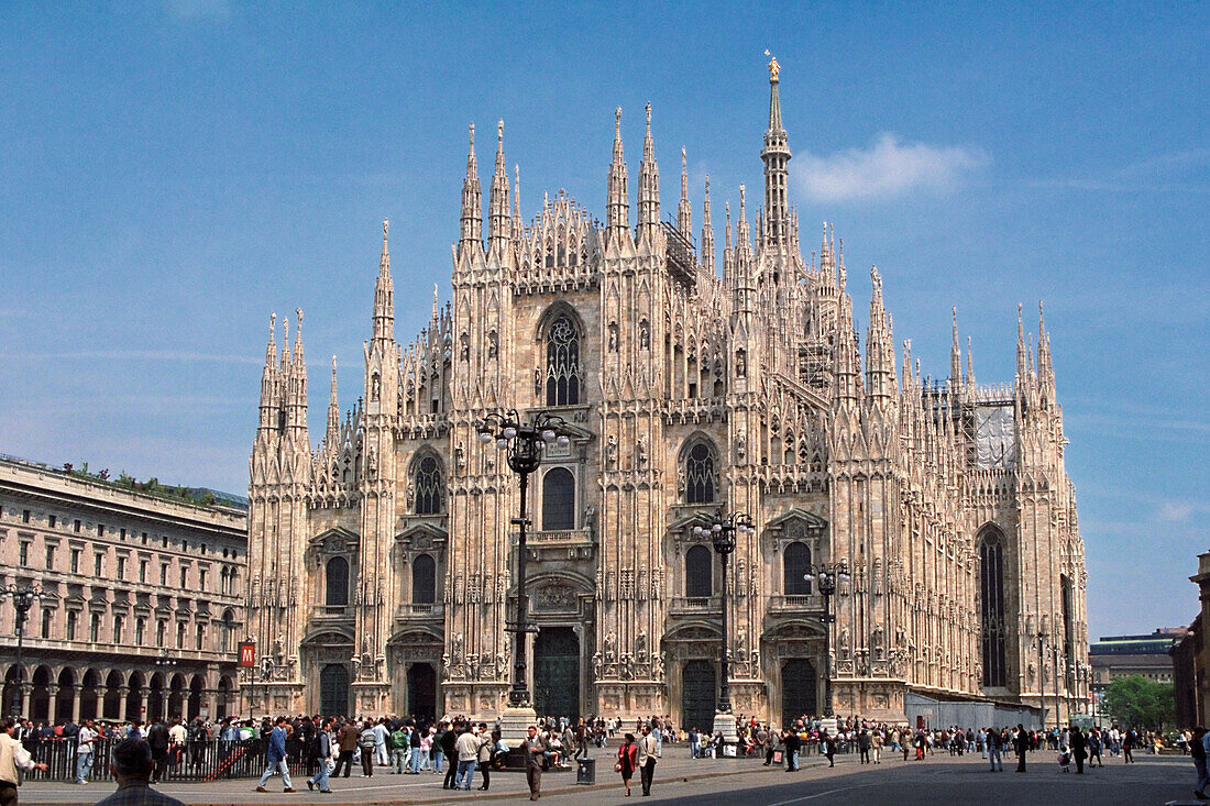 People walk in Duomo Square (Piazza del Duomo) in front of the Duomo Cathedral. Milan, Italy.