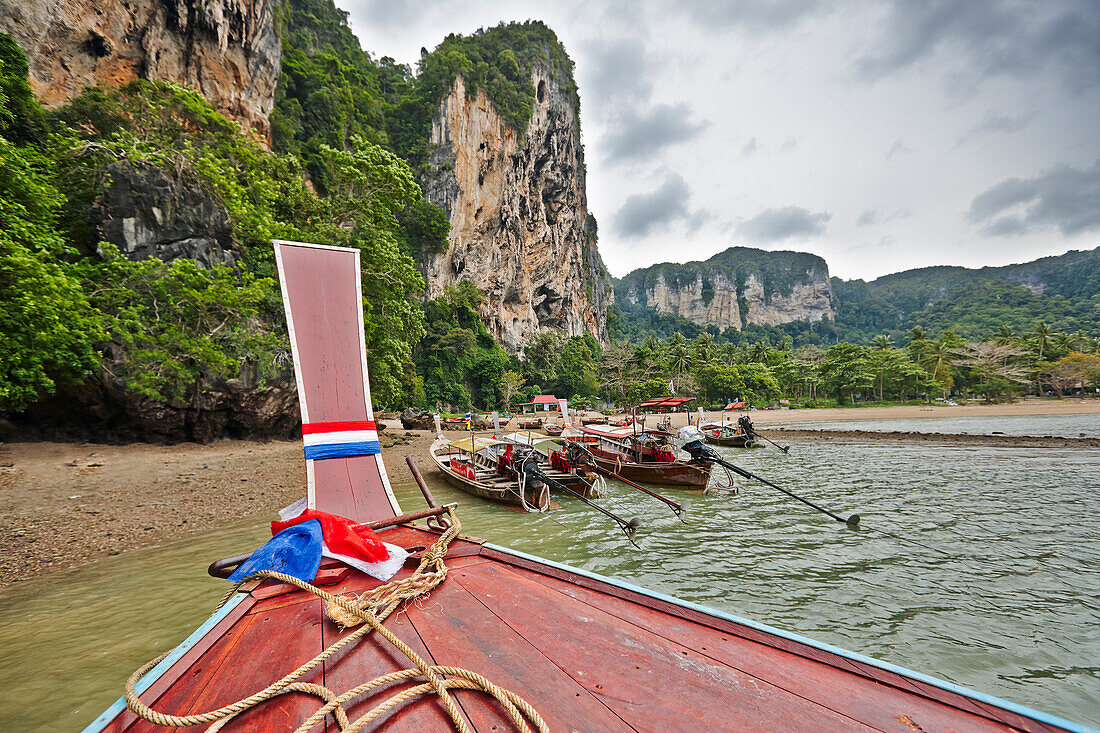 Bow of traditional Thai long-tail boat navigating Tonsai Bay near West Railay Beach. Krabi Province, Thailand.