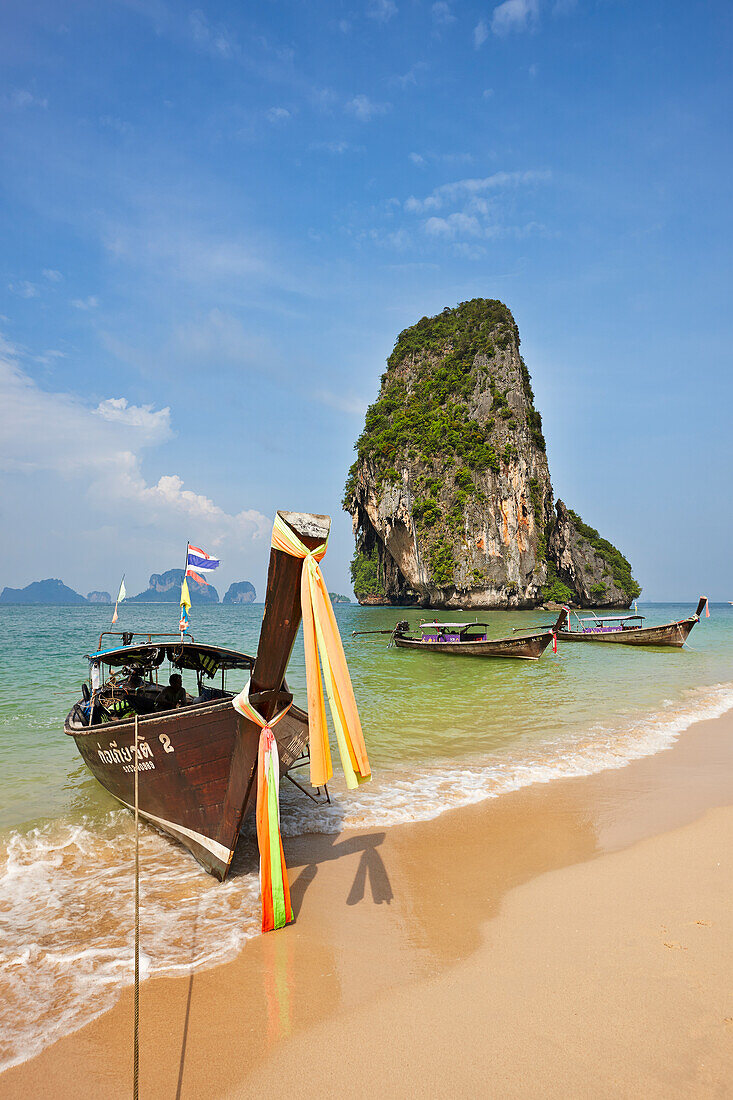 Traditionelle thailändische Longtailboote, die am Phra Nang Beach in der Provinz Krabi, Thailand, vor Anker liegen.