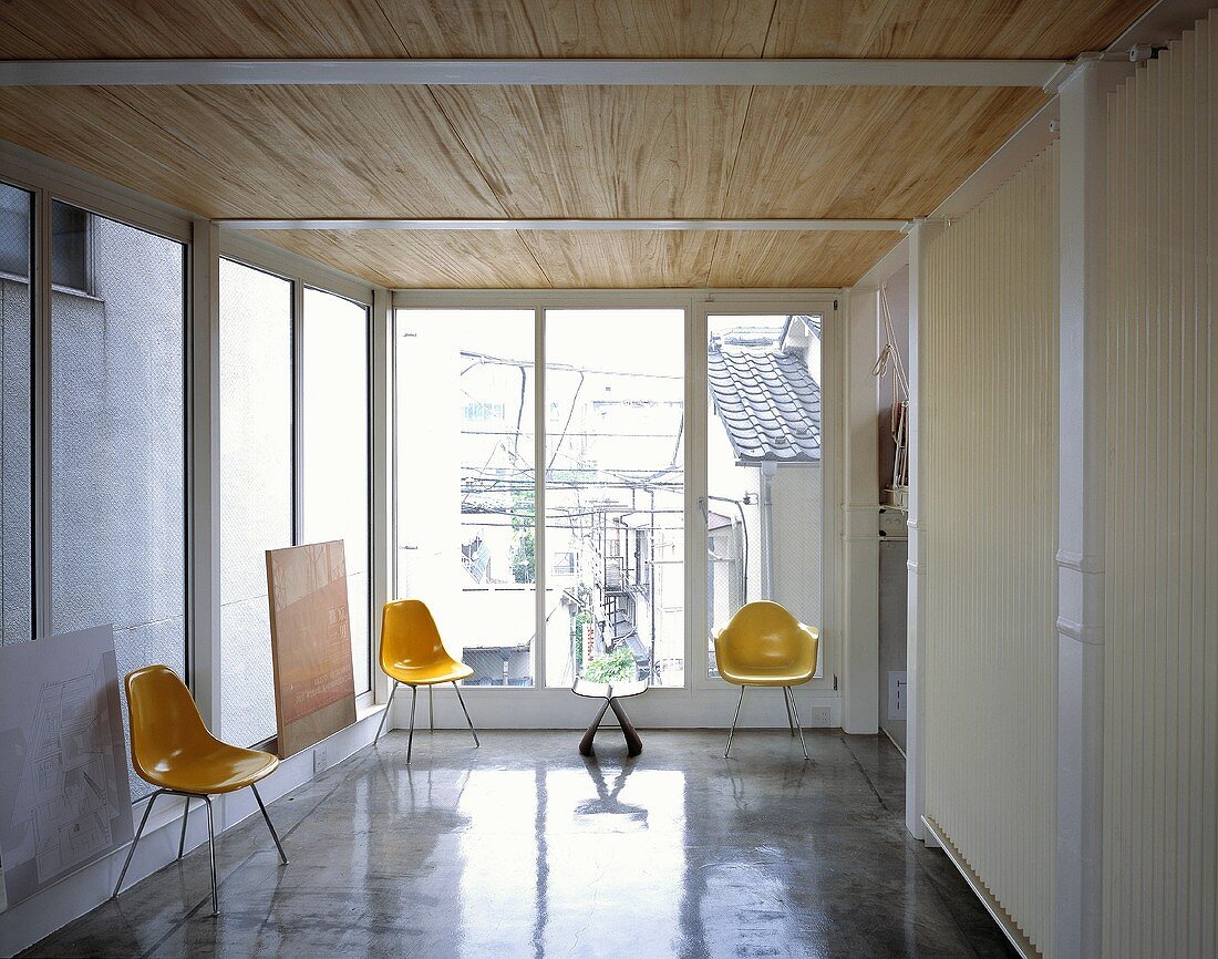 Yellow plastic chairs in an anteroom with a highly polished concrete floor