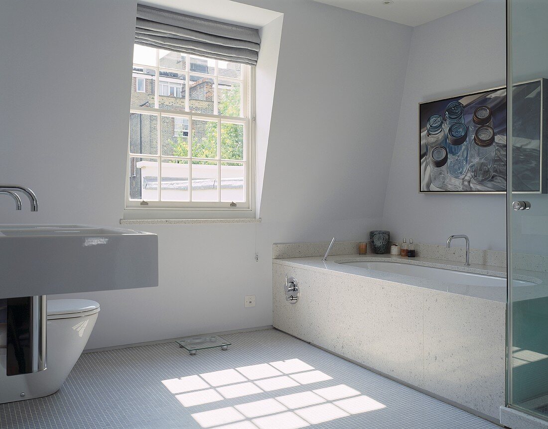 Weisses Designerbad mit Steinfliesen an Badewanne und weißem Mosaikfliesenboden