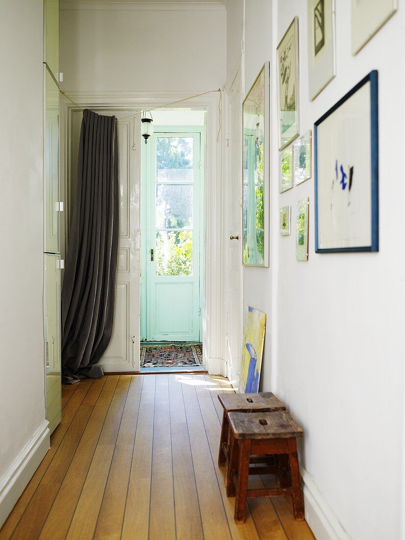 Flur mit Holzdiele und Vorhang vor der Eingangstür in einem schwedischen Haus