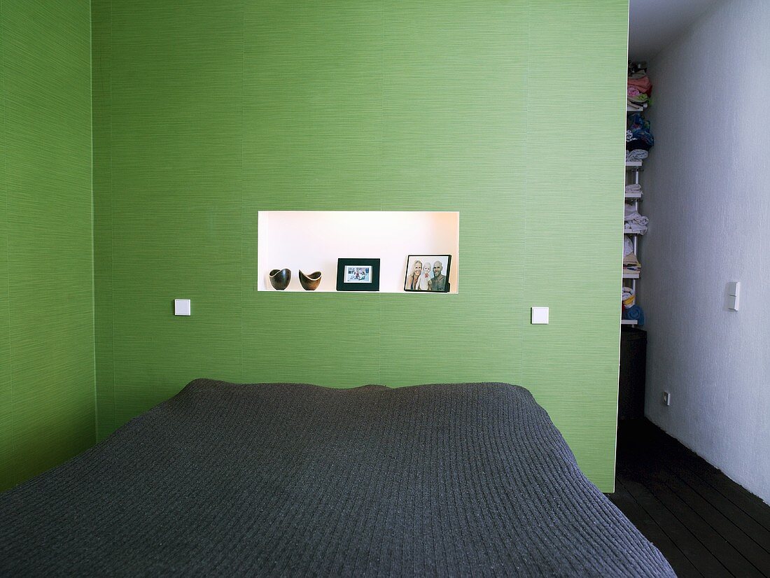 Ein Doppelbett in einem Schlafzimmer mit grünen Wänden