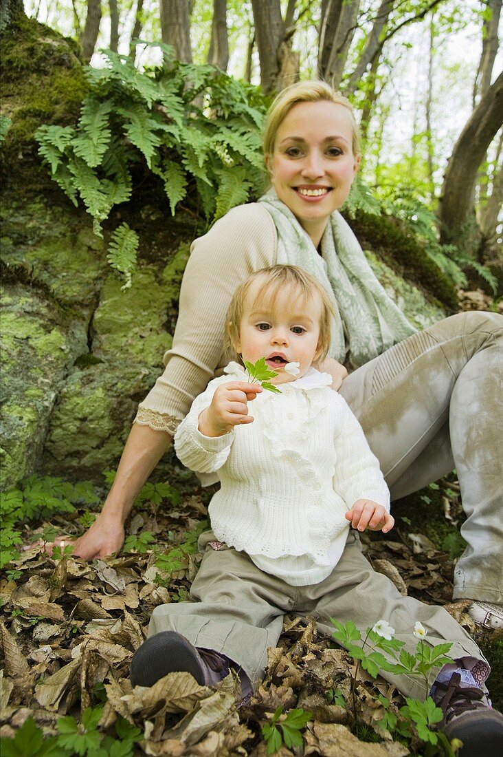 A mother and child sitting in a forest