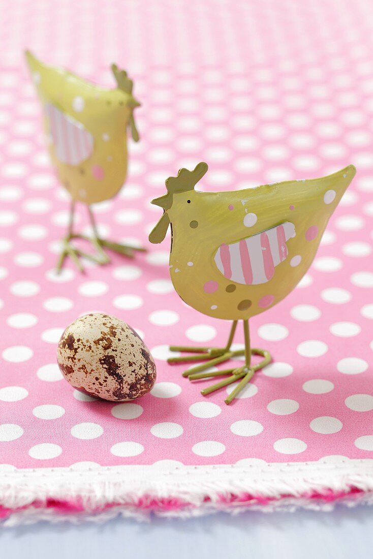 Metal chicken ornaments and a quail's egg