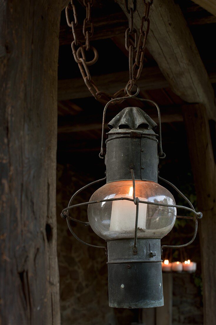 An old lantern with a candle as lighting on a terrace
