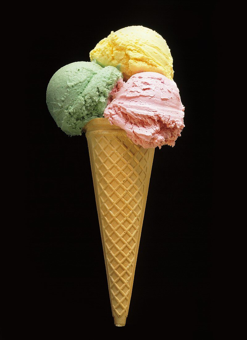 Pistachio, vanilla and strawberry ice cream in a cornet