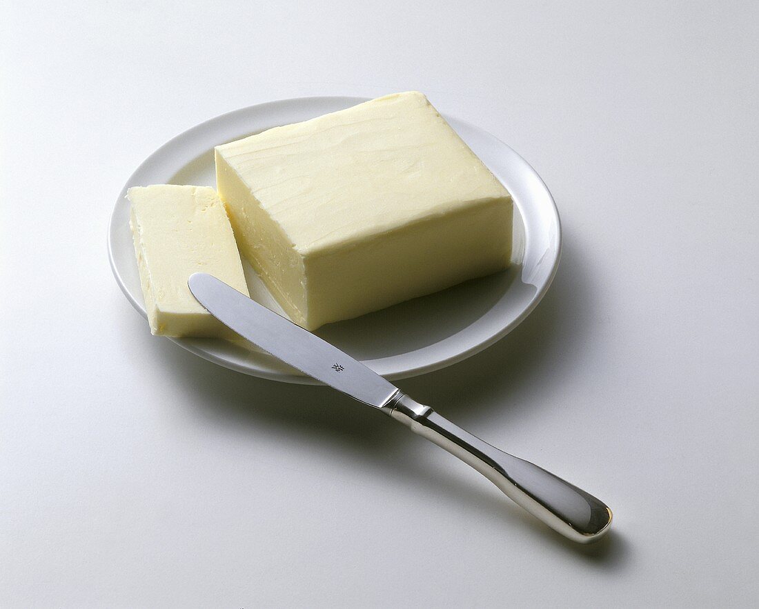 Angeschnittene Butter auf weißem Teller