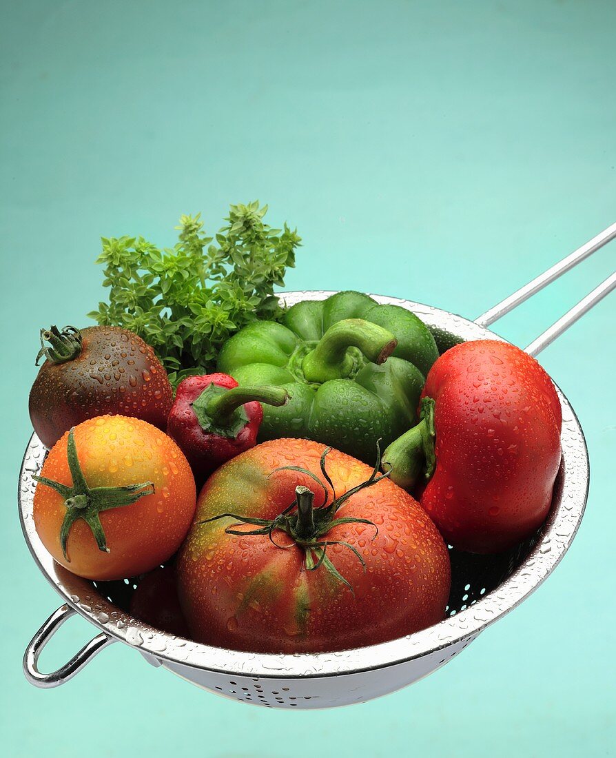 Washed tomatoes and peppers in a sieve