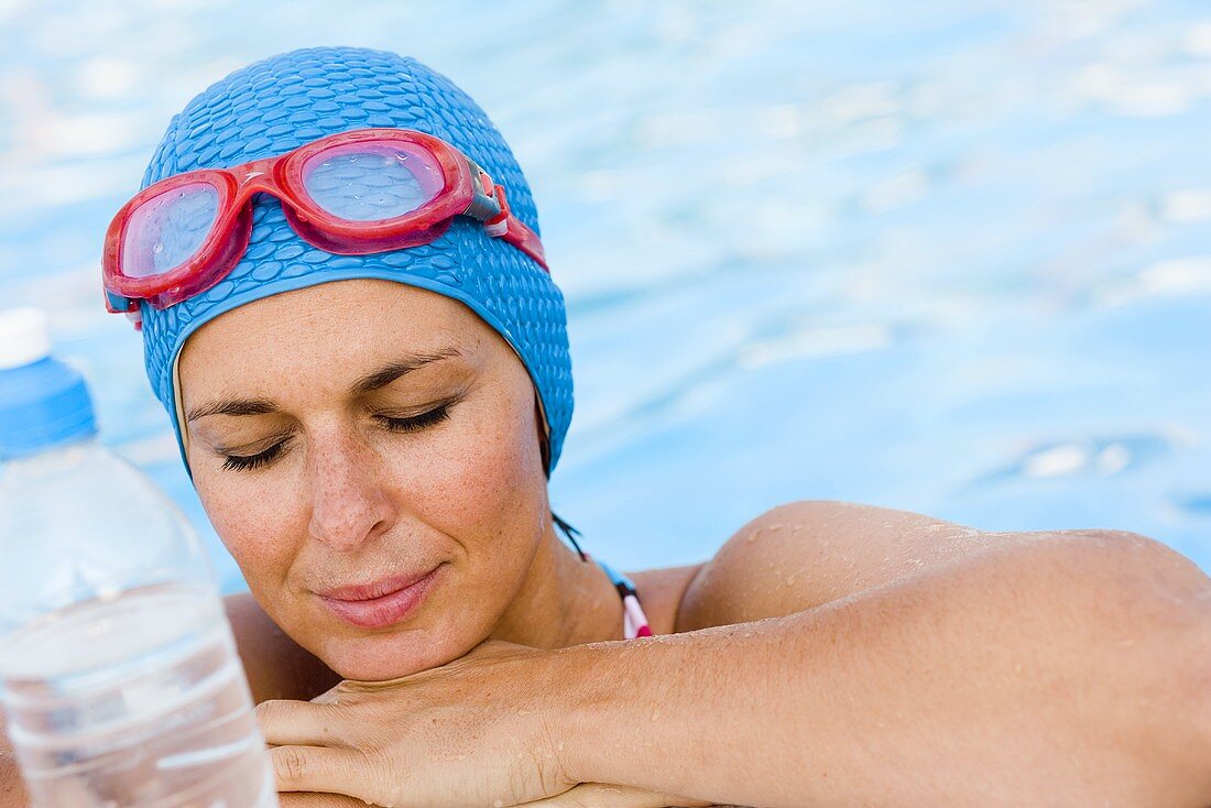 Frau mit Badekappe und Schwimmbrille im Schwimmbecken