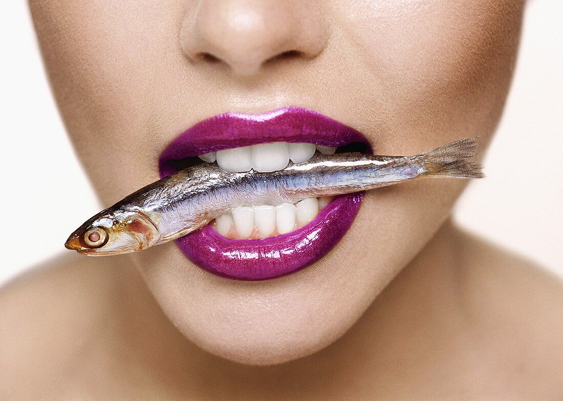 Woman with a sardine in her mouth