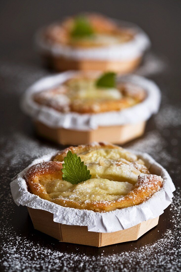 Three small apple tarts with icing sugar and mint