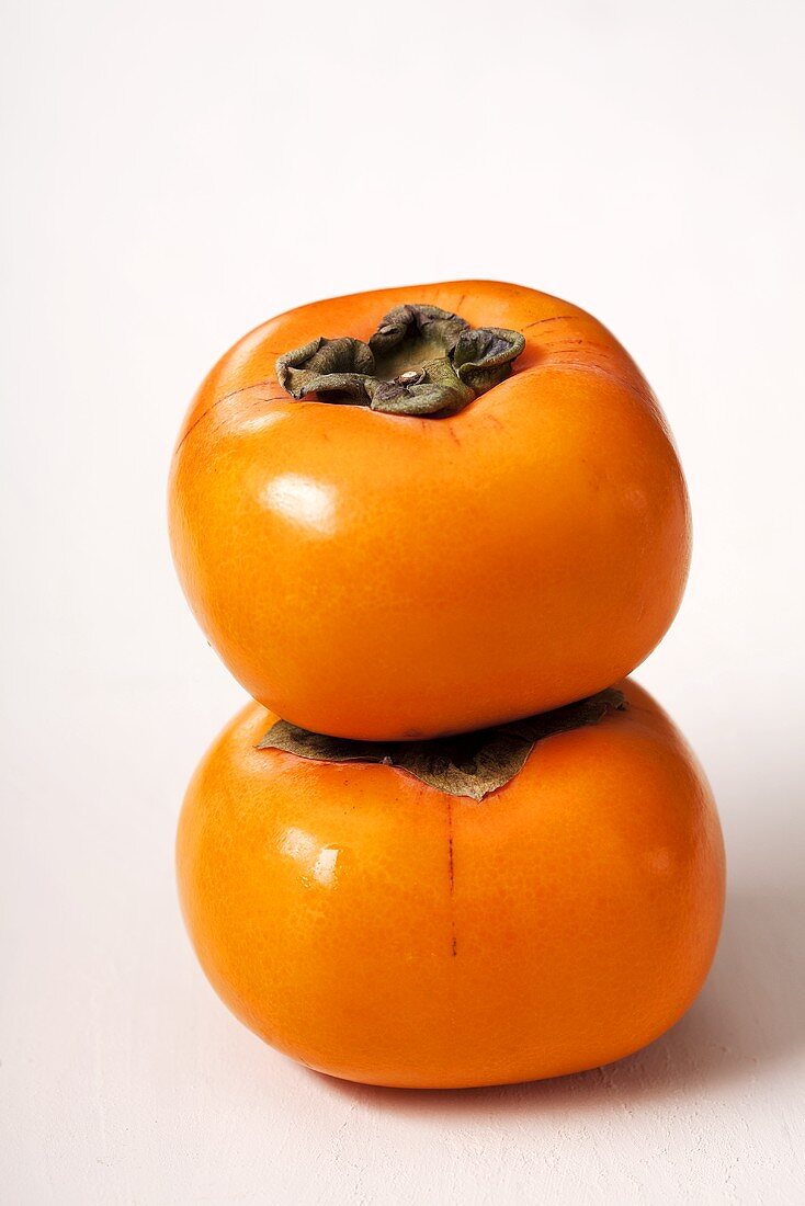 Two persimmons, stacked