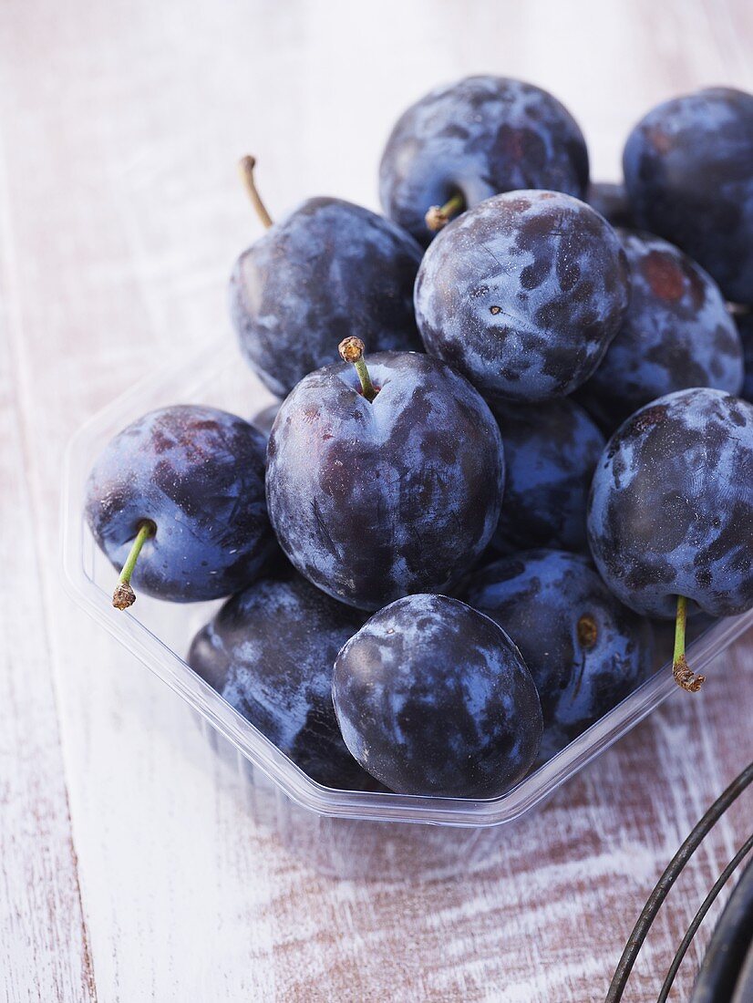 Fresh plums in plastic punnet