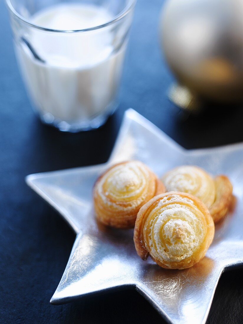 Quark pastry pinwheels on star-shaped silver plate, glass of milk